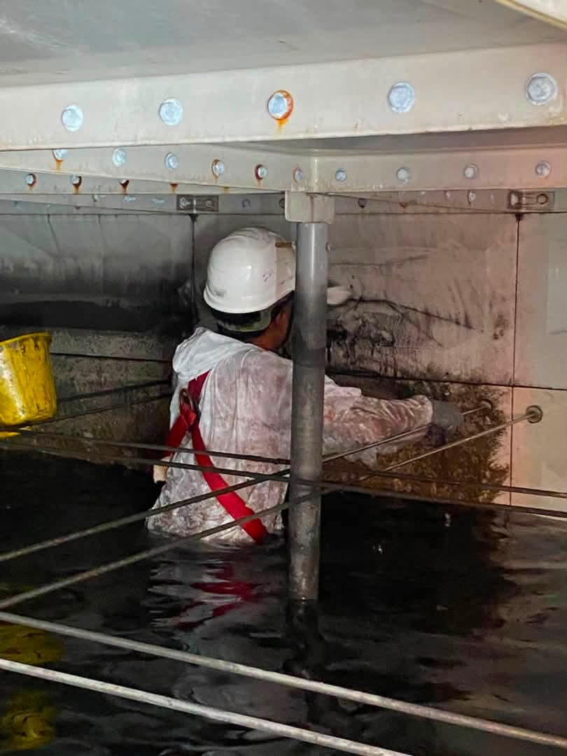 Crew member cleaning a tank interior