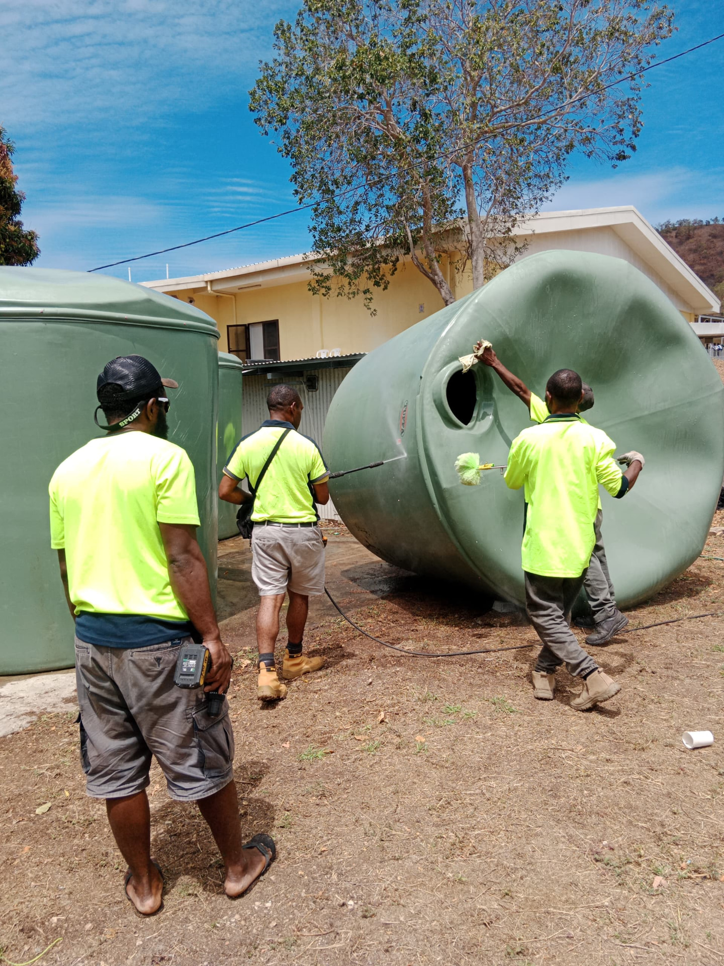 Crew working beside a green water tank
